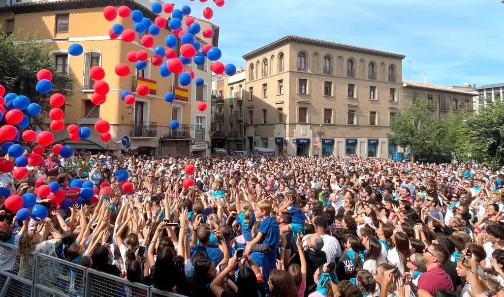 Lluvia de globos rojos y azules sobre la plaza abarrotada